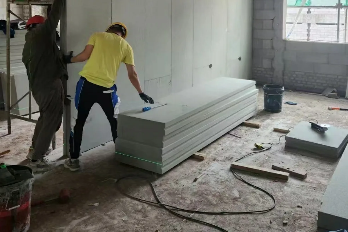 Workers installing foamed ceramic partition panels on site